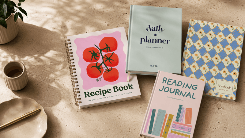 Yop & Tom recipe book, daily planner and reading journal on a sunlit table