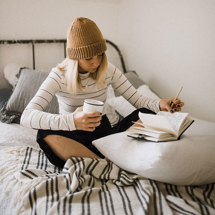 lady doing journaling on her bed
