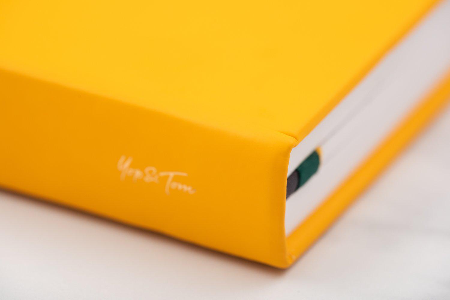 Close up of Yop & Tom logo on spine of power of 3 goal planner in yellow