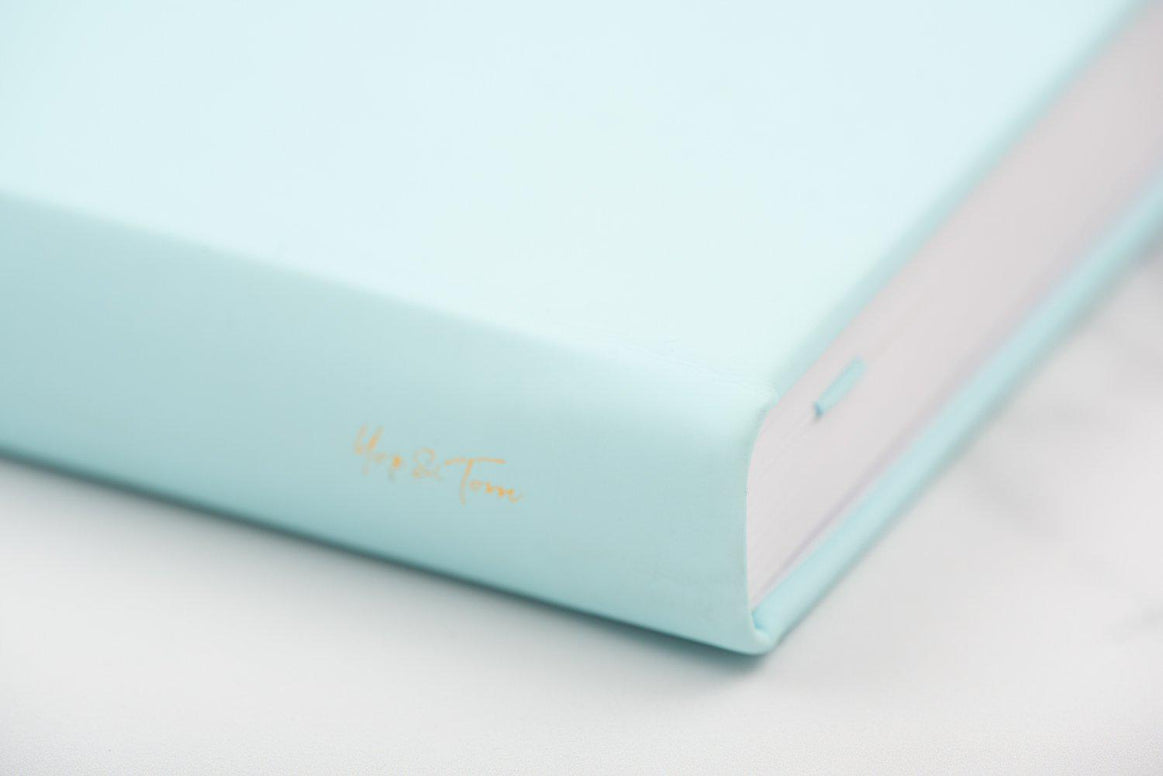 Close-up of Yop & Tom logo on eggshell blue journal