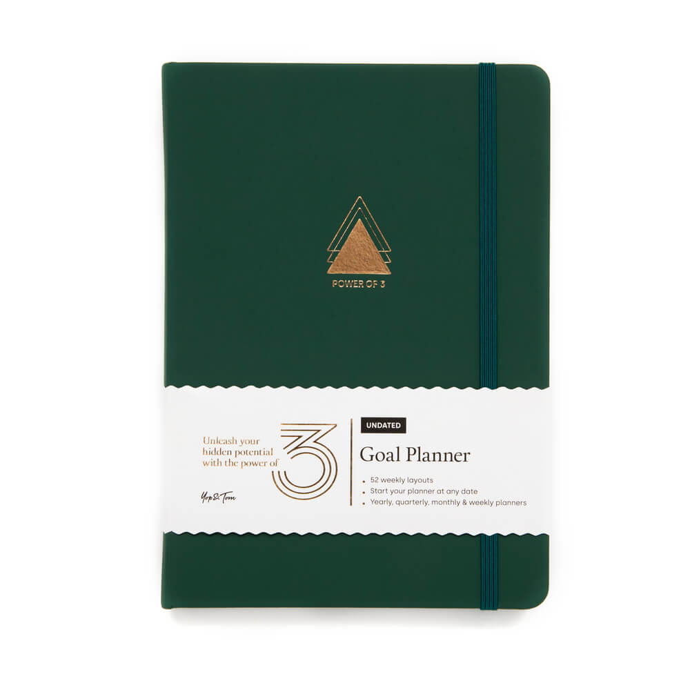 Power of 3 Goal planner in forest green front on shot showing gold emblem and paper sleeve