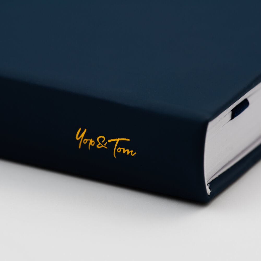 yop &amp; tom logo on spine of dark blue journal